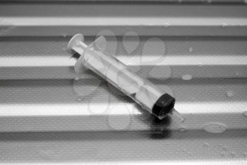 syringe on a metal surface
