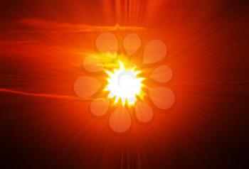 A star burst or lens flare over a black background. It also looks like an abstract illustration of the sun. 
