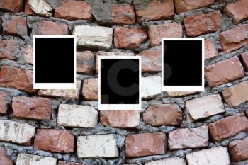 set of three old blank polaroids frames lying on a brick surface 