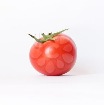 closeup of one red tomato on white background 