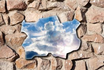 blue sky hole in aged brick wall background 