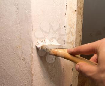 hand with a brush, paint the wall