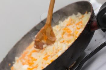 fried onions and carrots in the pan