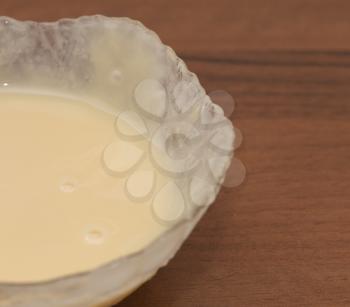 milk in a bowl on a wooden table