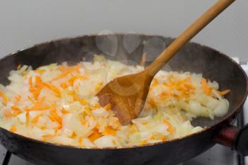 fried onions and carrots in the pan