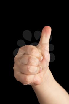 child's hand with a raised thumb up on black background