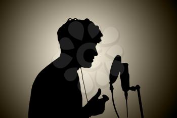 man in headphones singing into a microphone on a white background