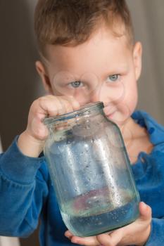 jar of water in the hands of the boy