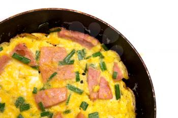 scrambled eggs with sausage in a frying pan on a white background