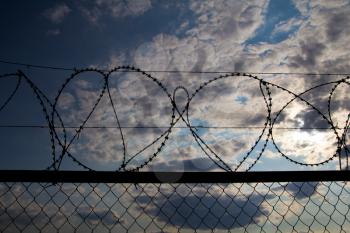 fence with barbed wire against the sky