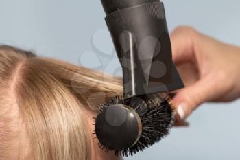 Hairdresser dries the hair in a beauty salon