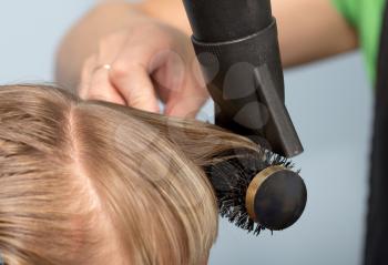 Hairdresser dries the hair in a beauty salon