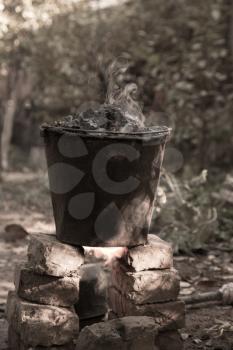 a bucket of tar on the fire, for roof repairs
