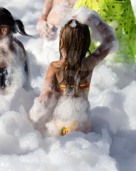 Youth at a foamy party on the beach .