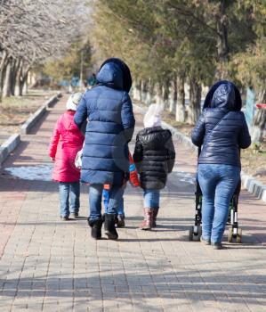 family with children walks in park