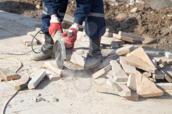 Worker cuts paving slabs