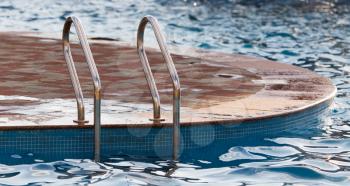 Metal ladder leading into the pool water