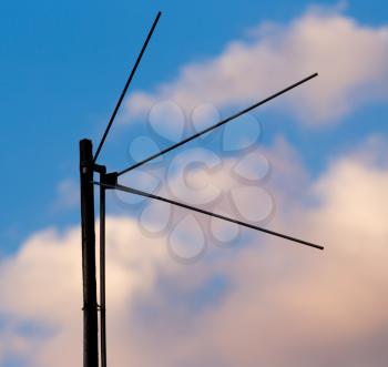 Tv antenna on the background of clouds at sunset
