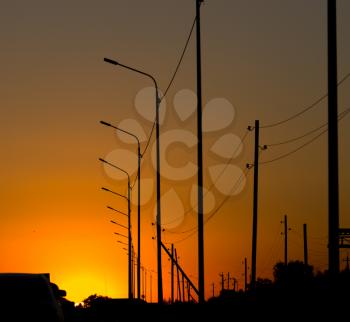 Electric wires on yellow sunset as background .