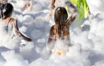Youth at a foamy party on the beach .