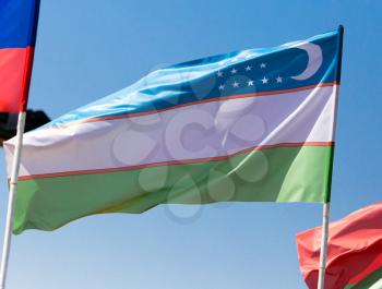flag of Uzbekistan against the blue sky .