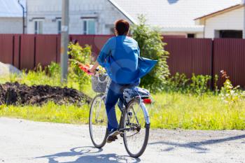 woman on a bicycle in the village .
