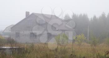 house cottage in the fog in the morning .