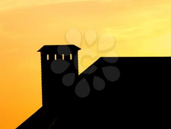 roof of a house with a chimney at sunset .
