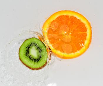 kiwi and orange in water on white background
