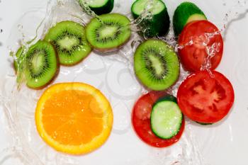 fresh fruits and vegetables in water on a white background