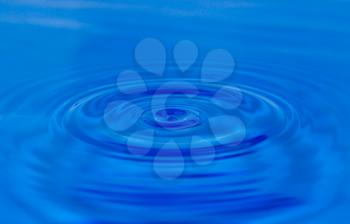 A drop of water falling in blue water