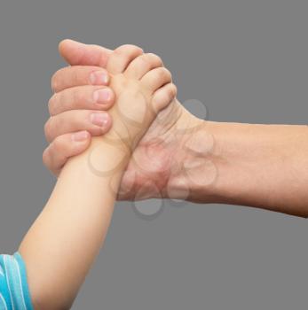 hands of father and son on a gray background