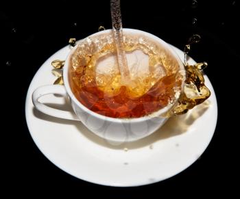 tea saucer with splashes on a black background
