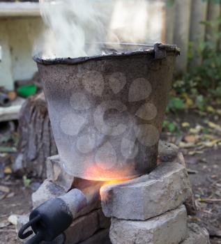 flame from a gas burner heats the bucket