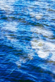 sky with clouds reflected on the water surface with waves