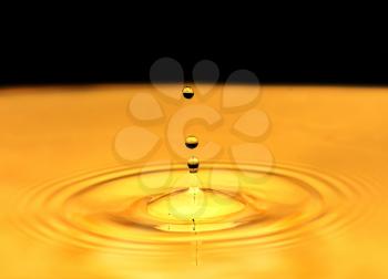 a drop of water falls in a golden water. macro