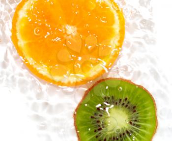 juicy kiwi and orange in water on a white background. macro