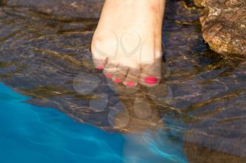 pedicure on foot in the water on the rocks