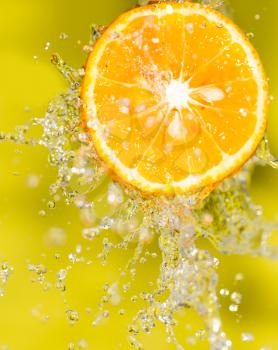 orange in water on a yellow background background