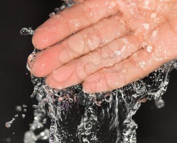 hand in water on a black background