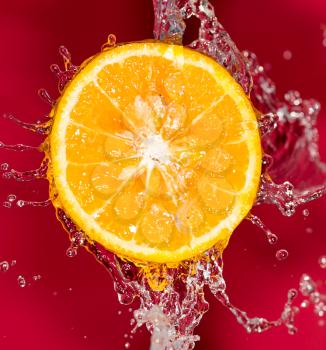 orange in water on a red background background