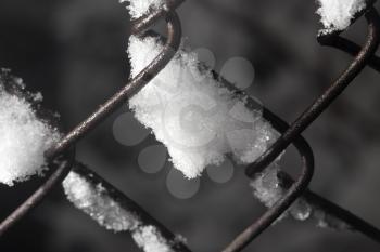 snow on the fence. close-up