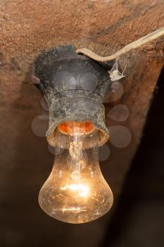 old lamp burning on a wooden ceiling
