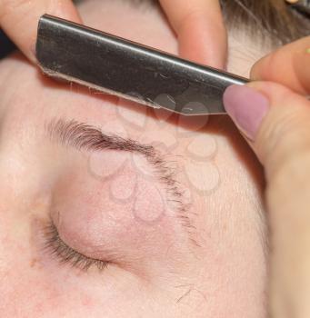 grooming eyebrows in a beauty salon