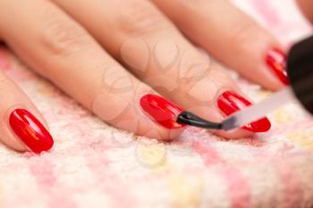 nails painted red nail polish in a beauty salon