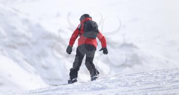 Snowboarding man at flattened piste - slope
