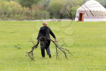 woman carrying firewood in a yurt