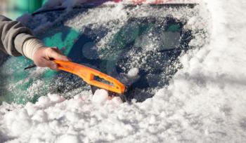 scraping snow from car winter