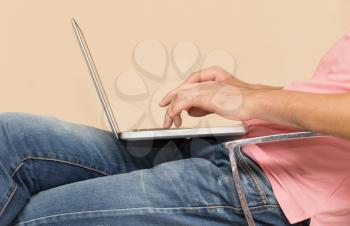 man in jeans with a laptop