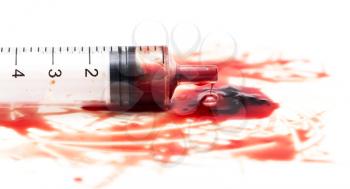 syringe and red blood on white background